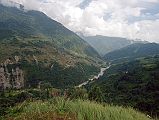 605 Looking Towards Chomrong From Chiule With Khumnu Khola Below I descended from Tadapani once again with a forest canopy to Chiule (2170m). I was pleased to finally leave the forest behind as I emerged into the open. The descent was steep again all the way to the bridge over the Khumnu Khola at 1930m, arriving at 13:00. The trail went steeply up the other side before leveling off as I passed thru Ghurjung (2010m). Once again I had to huff and puff steeply up before the trail finally leveled off all the way to Chomrong (2210m), arriving at 15:00